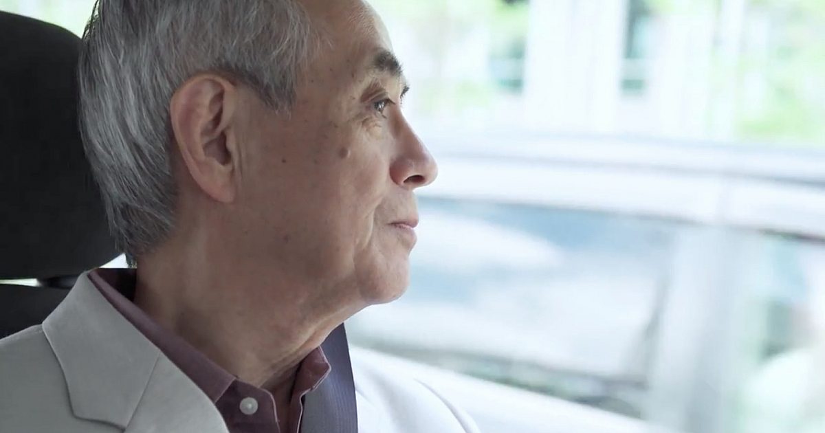Older man seated in a moving vehicle gazing thoughtfully out the window
