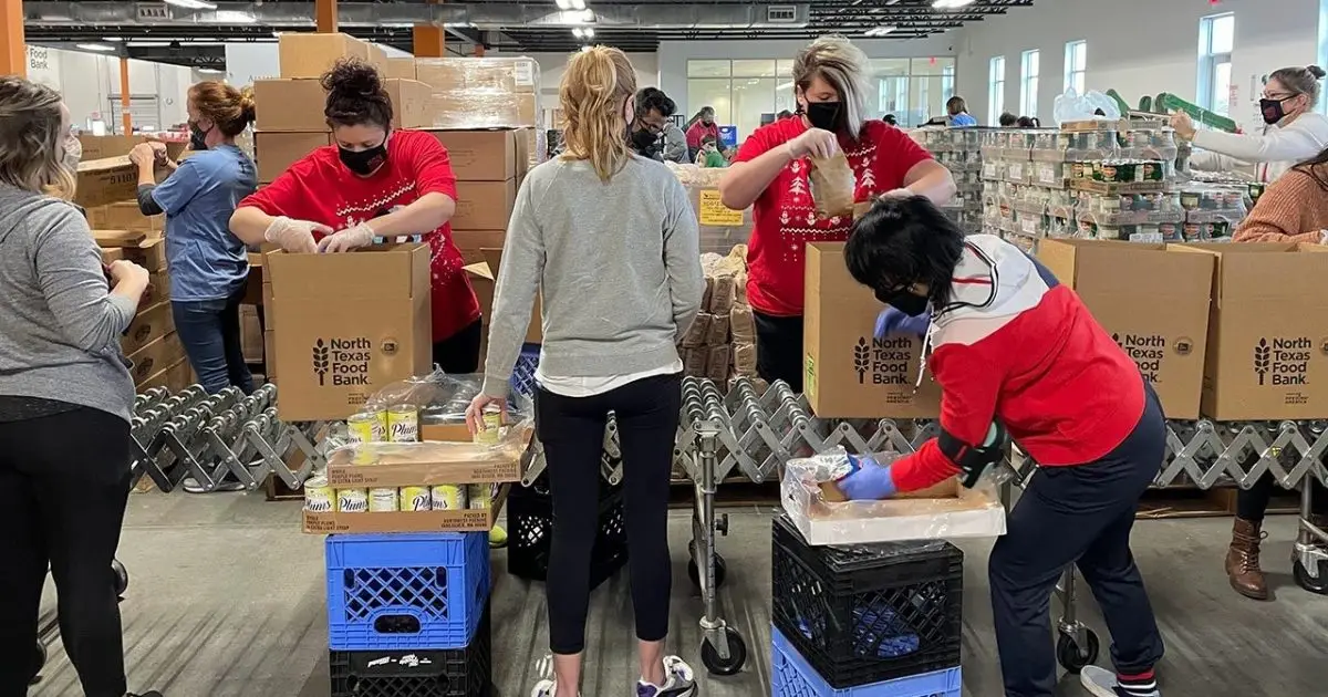 Volunteers in holiday sweaters packing food boxes at the North Texas Food Bank