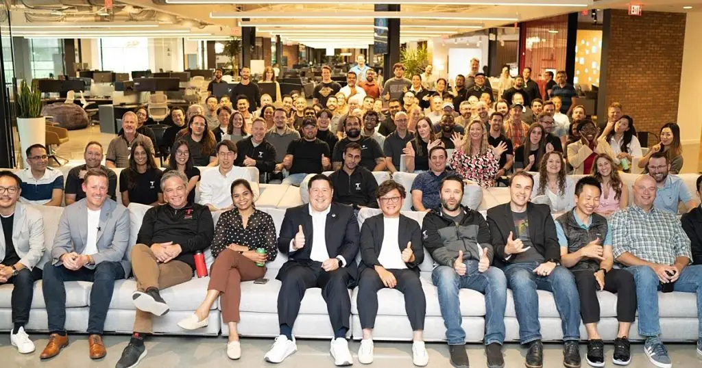 Large group of employees seated together on couches for a company gathering