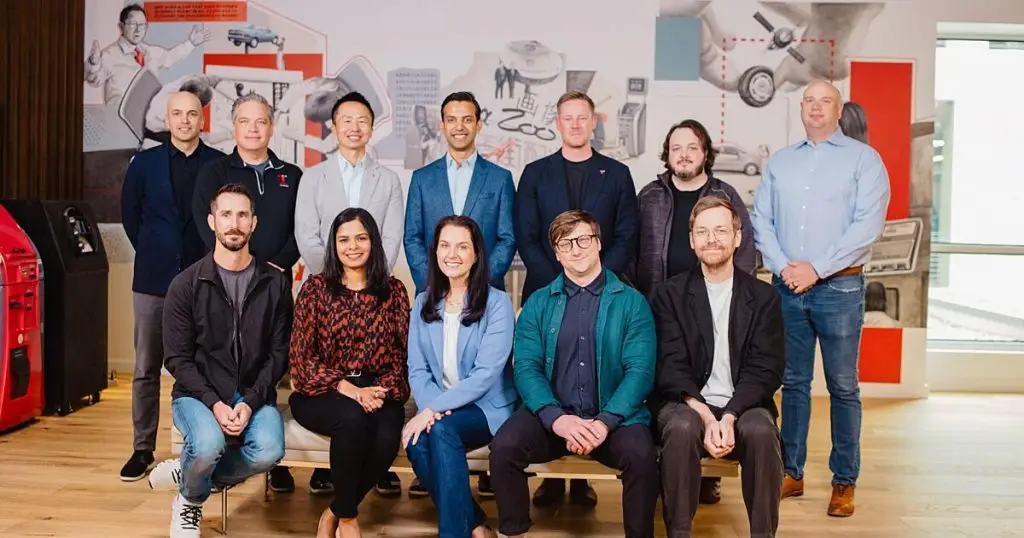 Group of eleven Toyota Connected leaders posed in front of a colorful office mural
