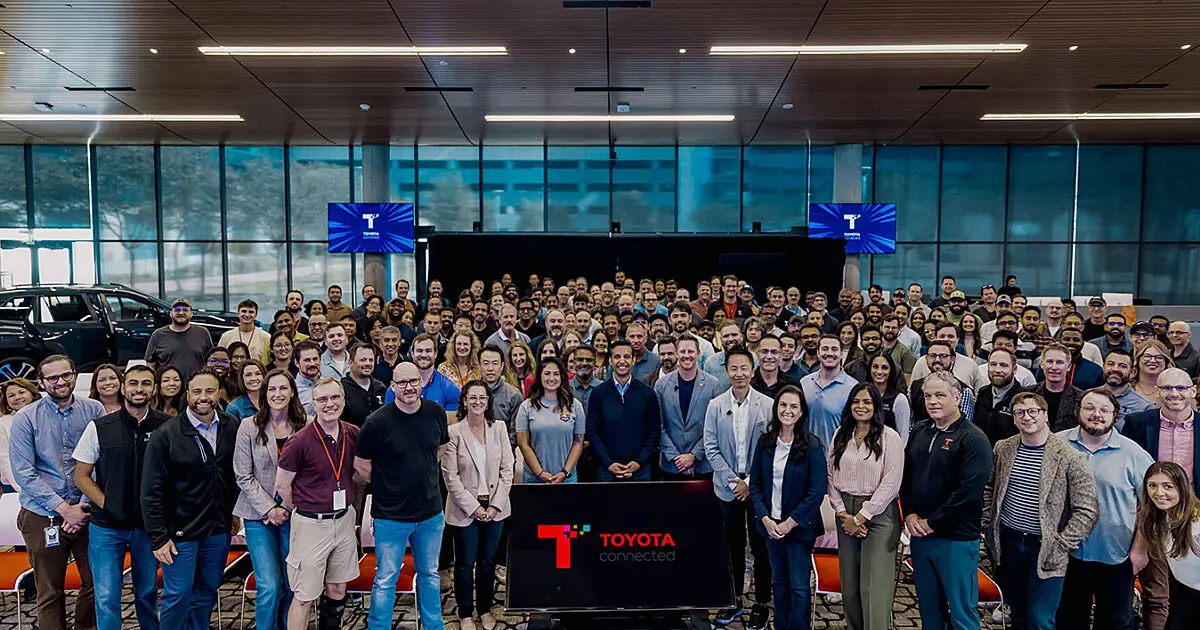 Large Toyota Connected team posing together for a group photo at an event
